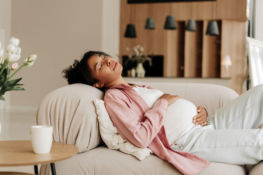 A serene pregnant woman preparing for sleep with a maternity pillow.