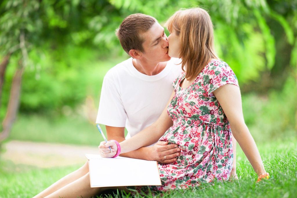 A pregnant mother with her partner, sitting calmly and reflecting on her birth plan.