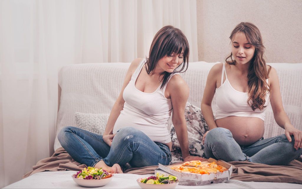 A pregnant woman expecting momo twins, consulting with her doctor during an antenatal appointment.