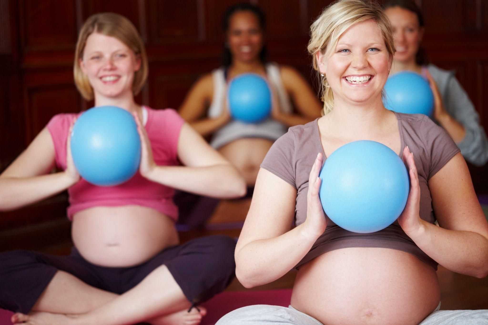 Pregnant women boost their fitness with safe exercises at antenatal class.