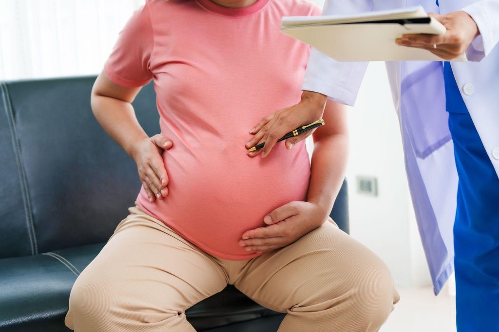 Pregnant woman works with a doctor to write her birth plan during her antenatal clinic.