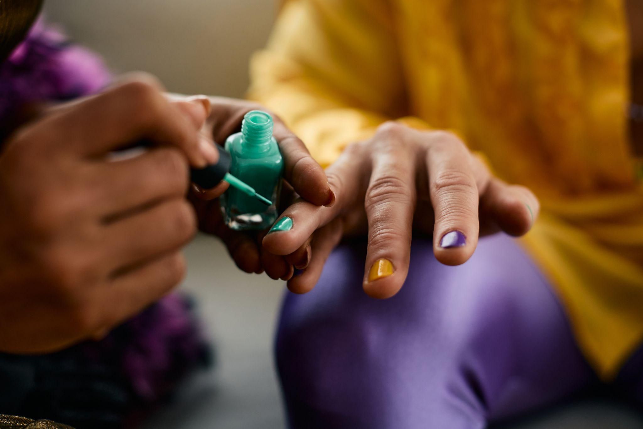 A pregnant woman applying '5-free' nail polish safely.