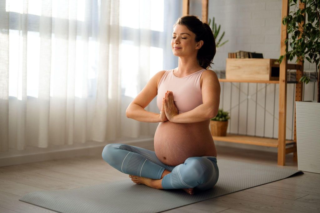 Expectant mum practising prenatal yoga during pregnancy.