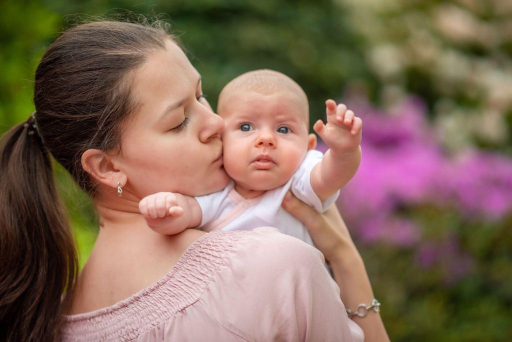 A confident new mum holding her newborn with pride.