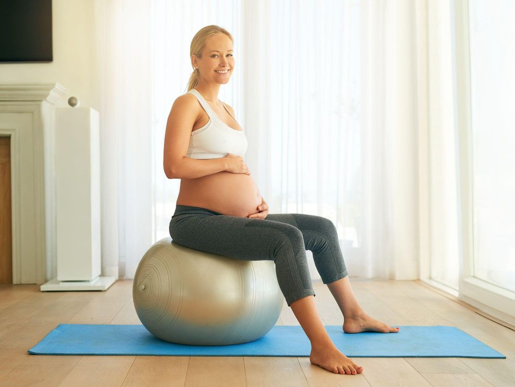 Pregnant woman exercising with a stability ball in third trimester