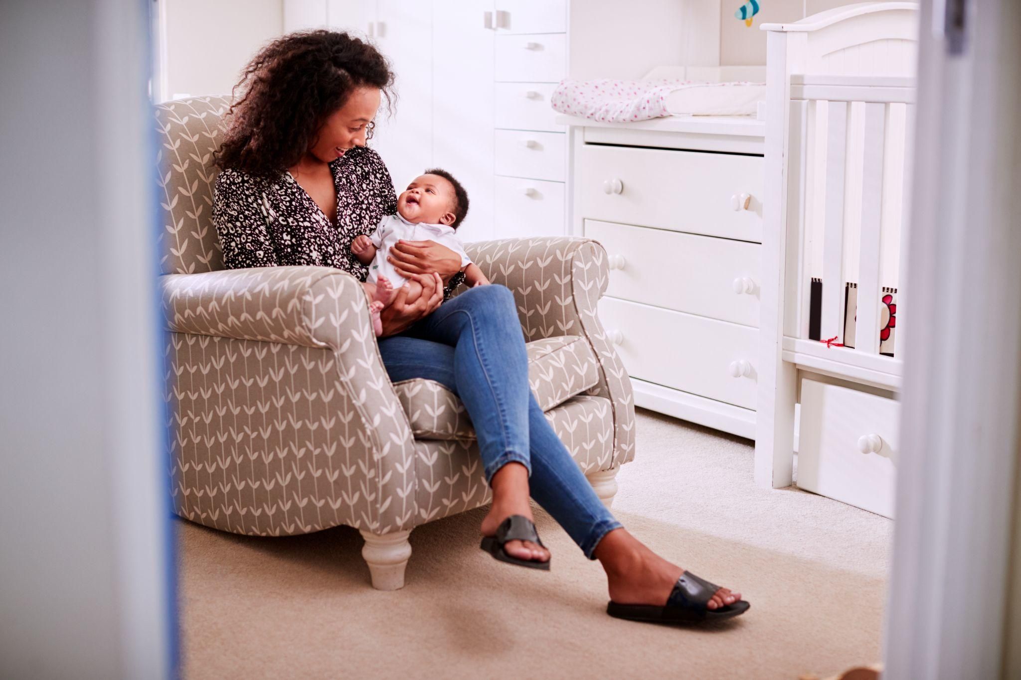 A neutral-coloured breastfeeding chair in a peaceful nursery setting.