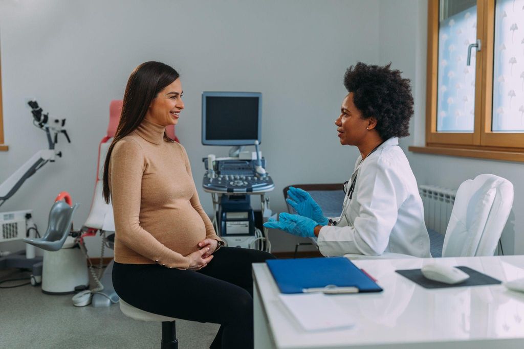 A pregnant woman consulting with a doctor during an antenatal appointment.