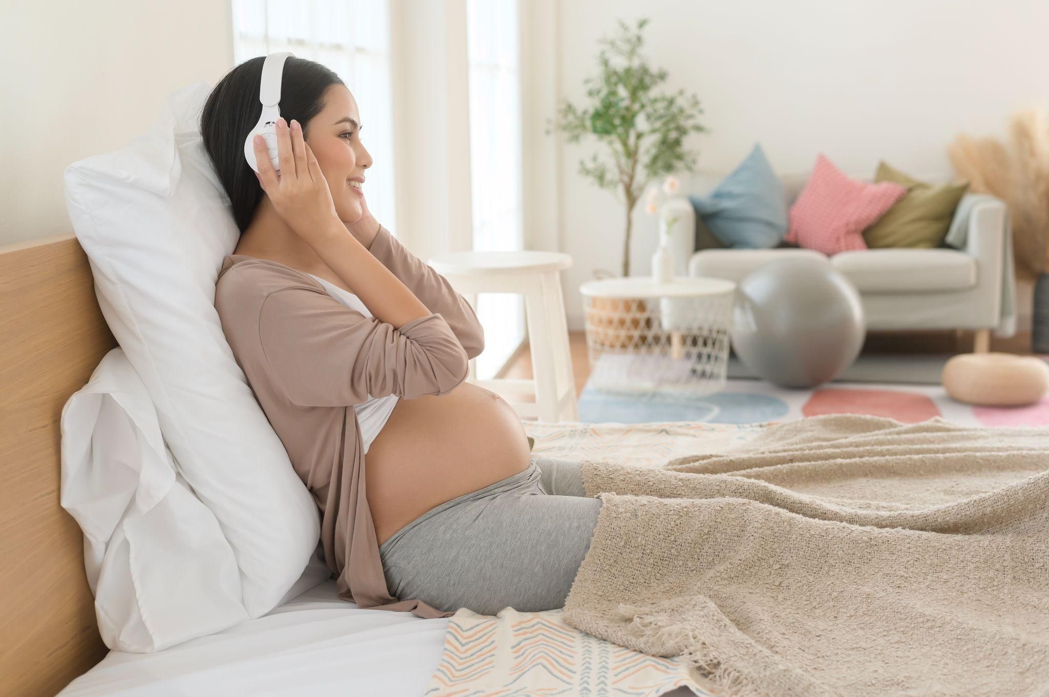 Pregnant woman enjoying a podcast while learning about antenatal care and education.