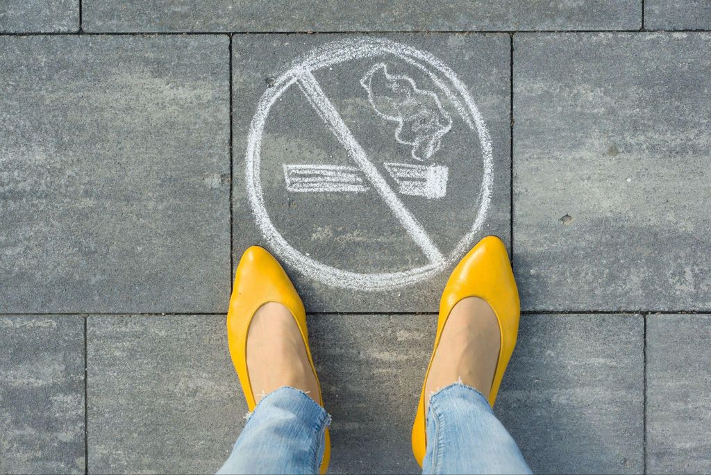 A pregnant woman holding a sign that reads "No Vaping" to promote a healthy pregnancy.