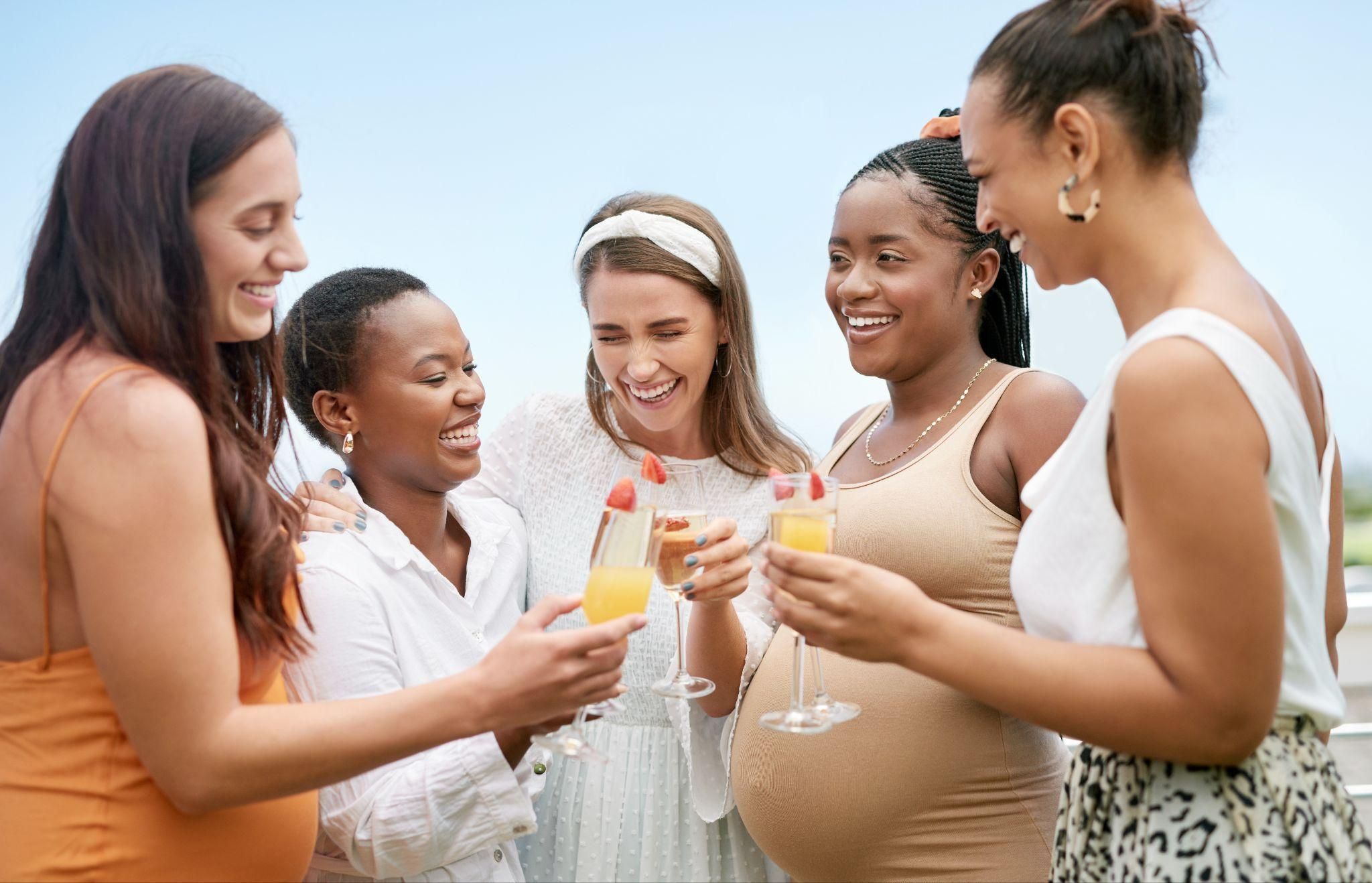 Happy women toast their pregnant friend at her baby shower.