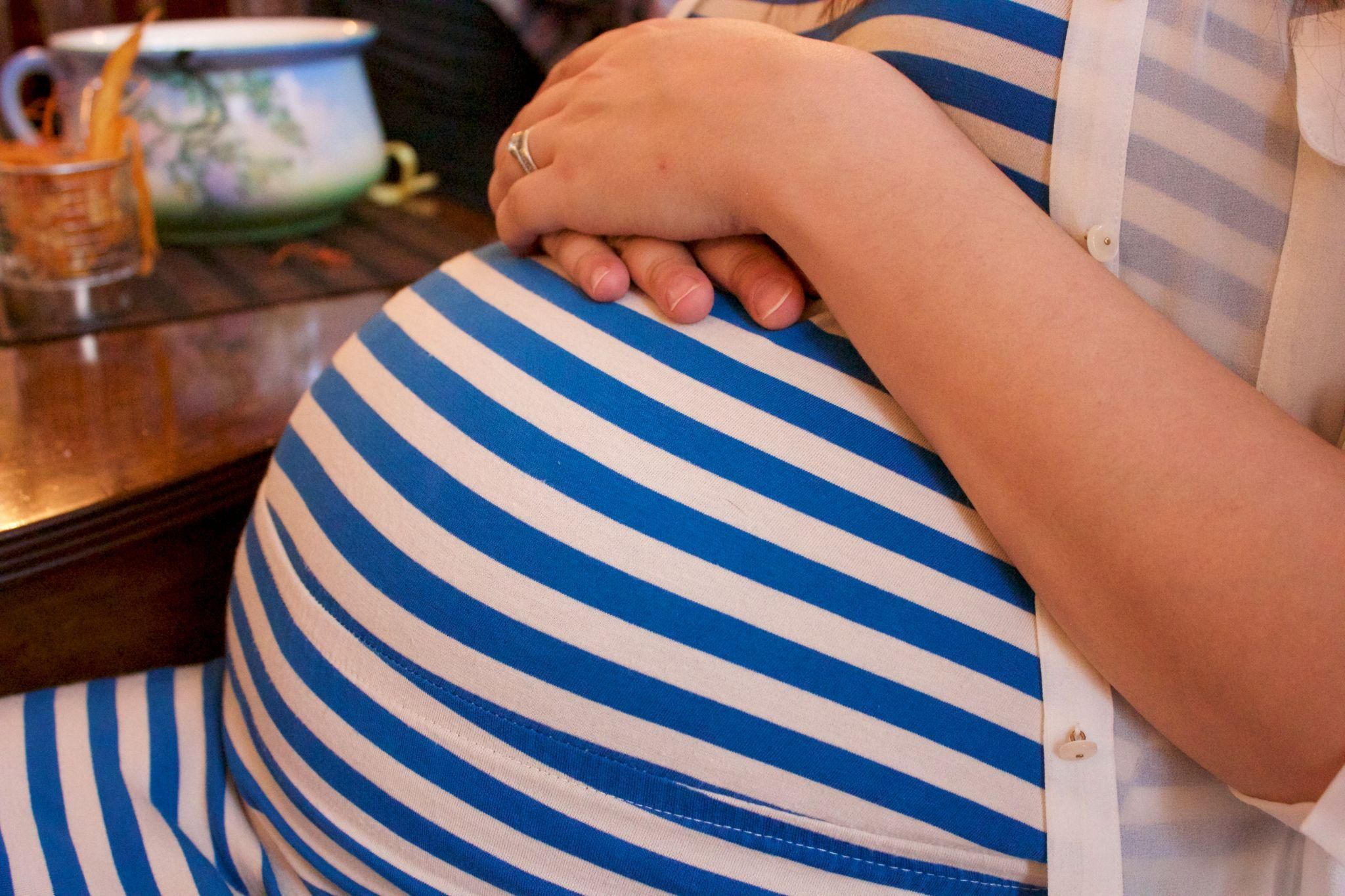 A mum-to-be tracking her baby’s antenatal movements while lying on her sofa.