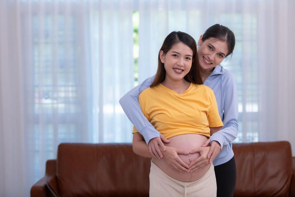 Pregnant woman offering emotional support to her grieving sister after a miscarriage.