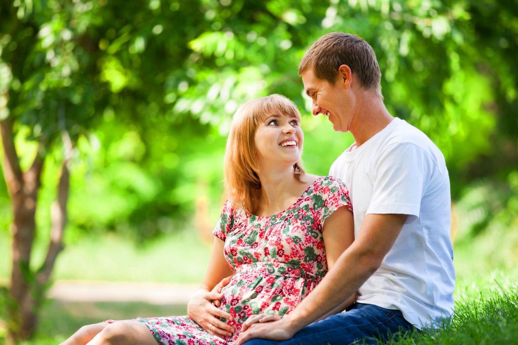 A smiling pregnant couple enjoying a moment of connection during pregnancy.