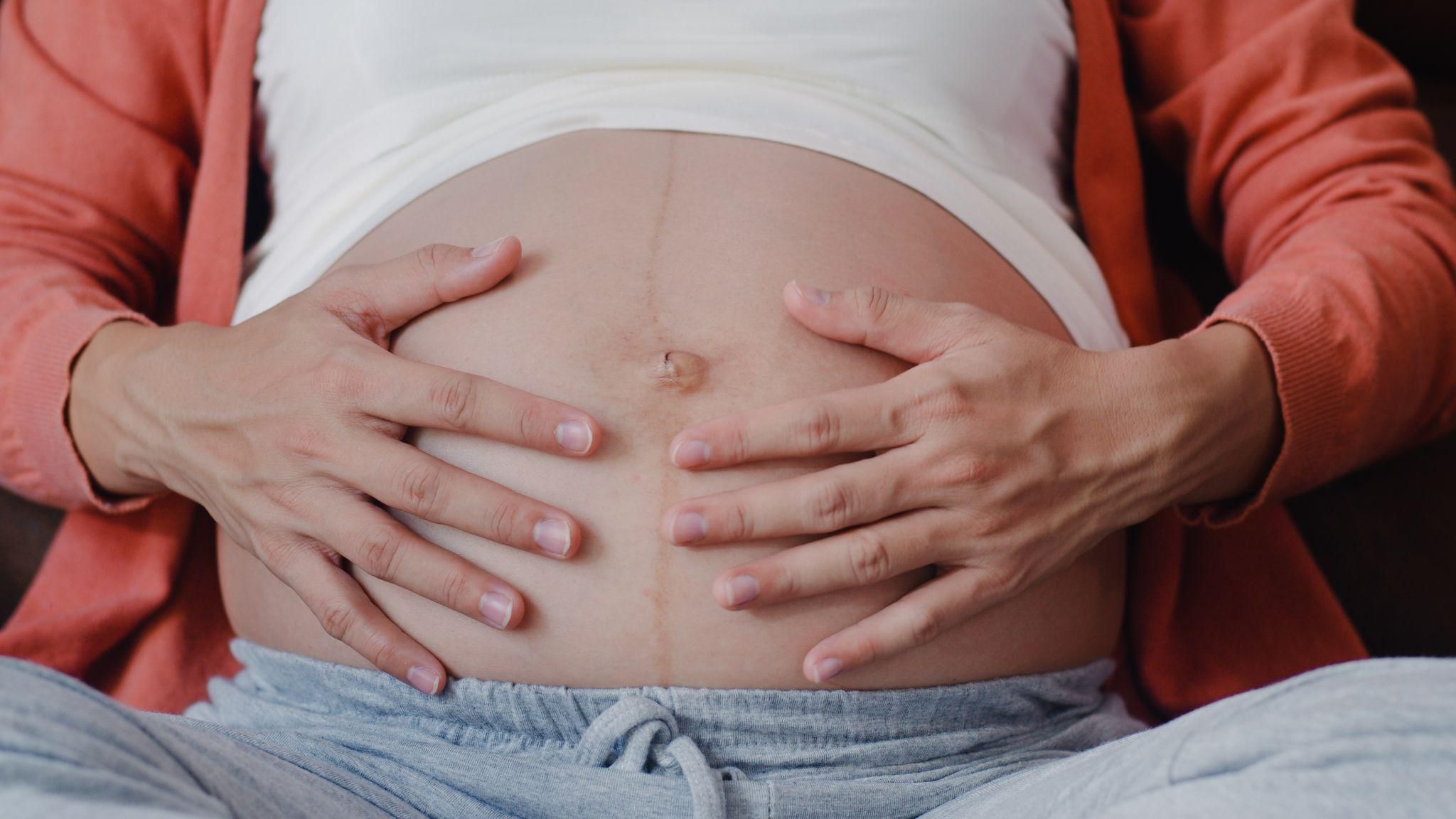 Pregnant woman experiencing lightning crotch pain, with a visual depiction of pelvic nerve discomfort.