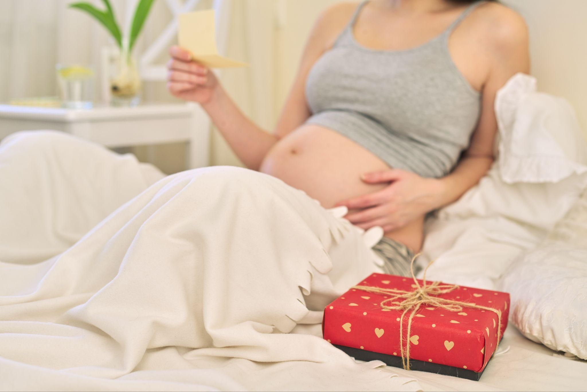 A pregnant woman relaxing with luxury pregnancy items.